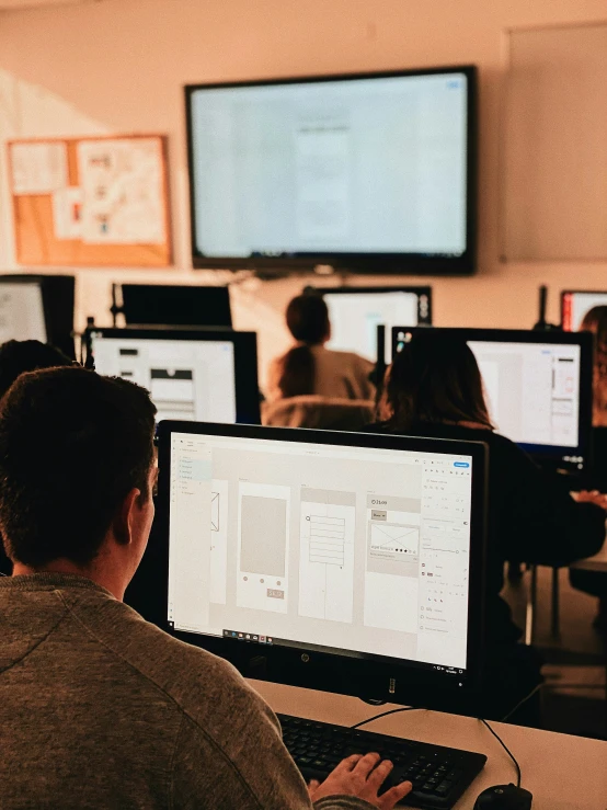 an office with desks full of computers and people on their own