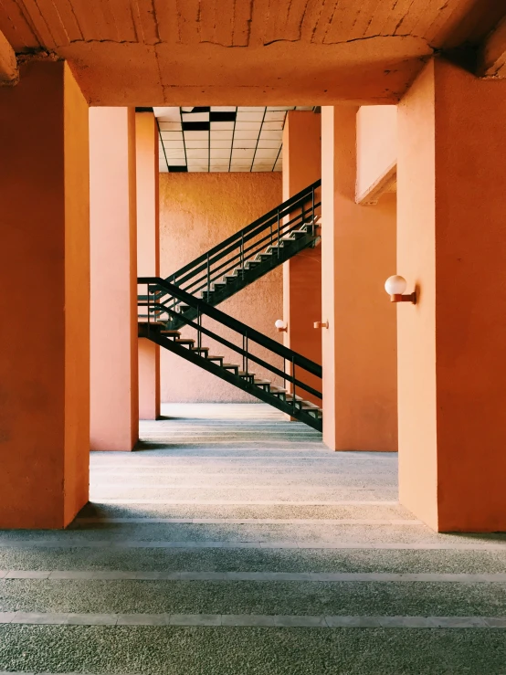 a black and white stairway between two orange walls