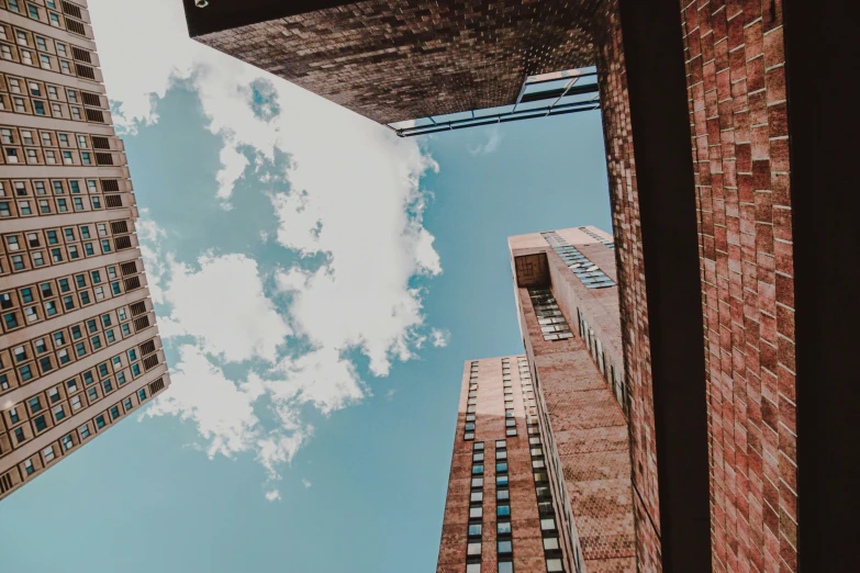 a picture of tall buildings under a partly cloudy blue sky