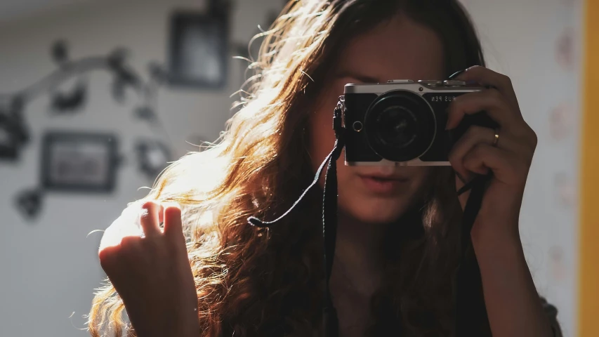 a woman holding up a camera to take a picture