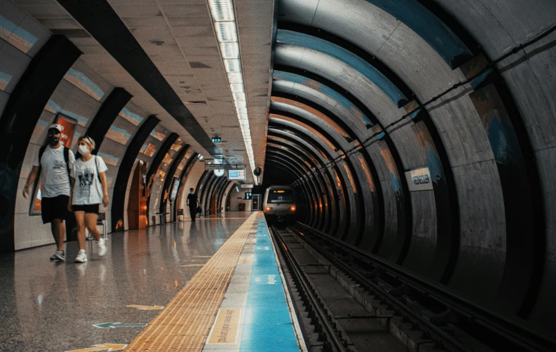 some people standing in a tunnel next to a train track