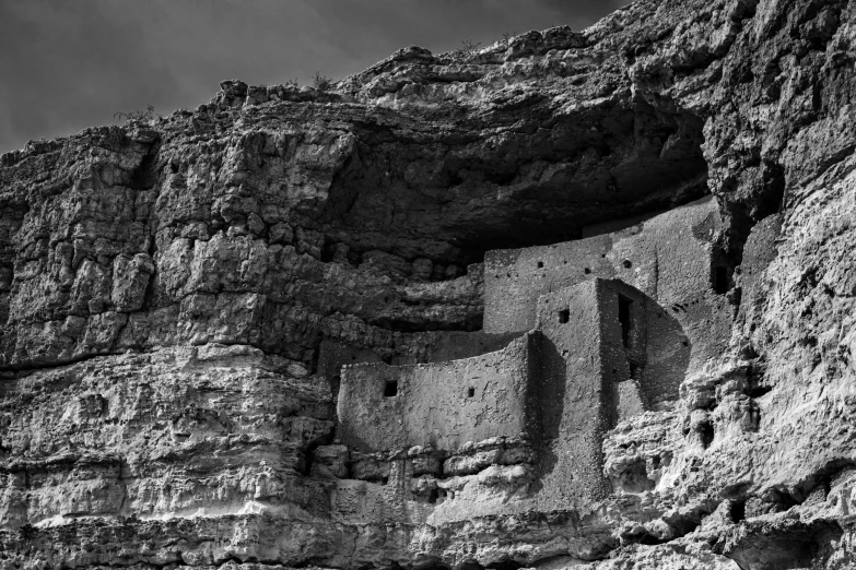 the ancient architecture of a cliff in black and white