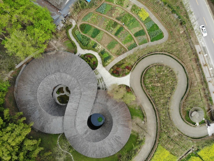 an aerial view shows a landscape with trees, winding paths and roads