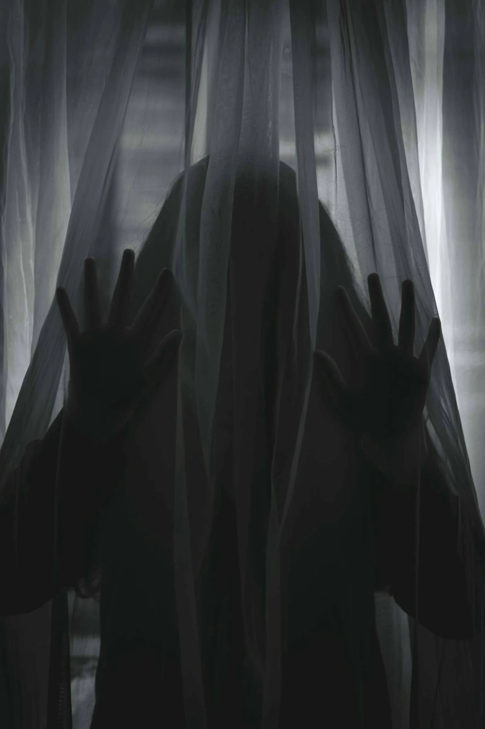 a person is hiding behind a curtain