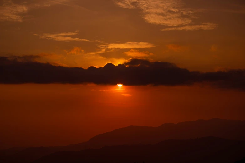 a very bright sun setting in the clouds