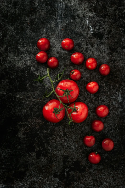 five tomatoes are arranged on a table top