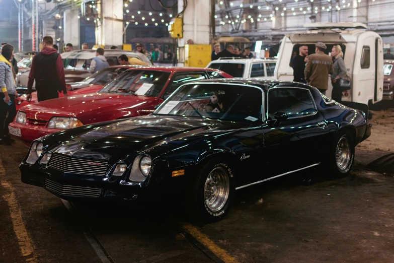 a black muscle is on display with other vehicles