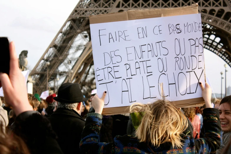 a protest with a sign written on it