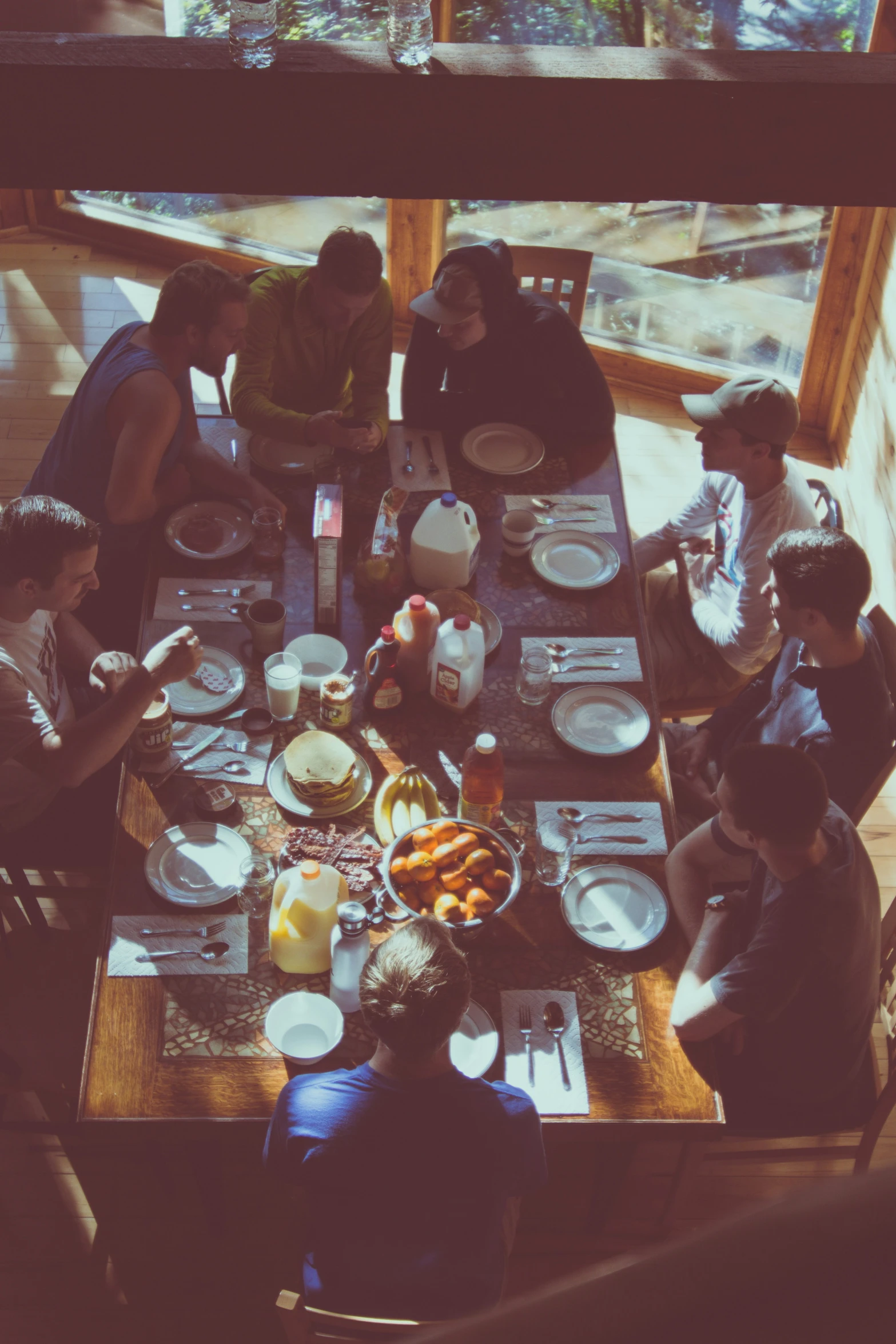 several people sitting at a dining table eating food