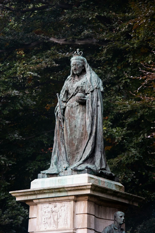 the statue is holding an owl near some trees