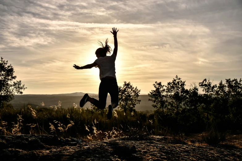 a person jumping in the air in the middle of a field