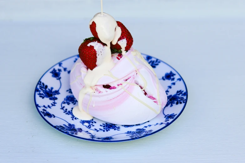 a strawberry cake sitting on top of a blue and white plate