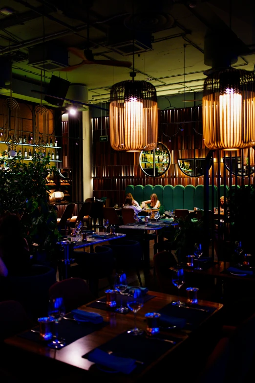 two chandeliers above a table in a dimly lit dining area