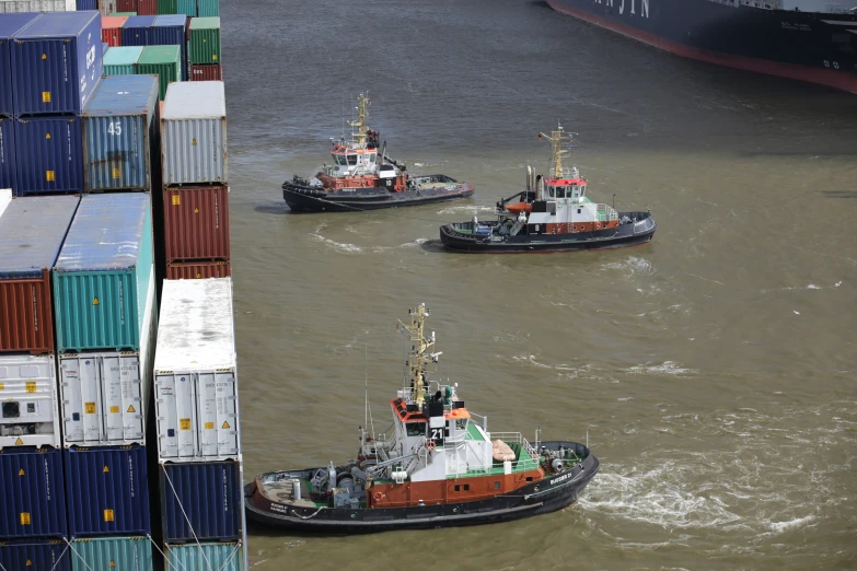 three ships sailing in a body of water near buildings