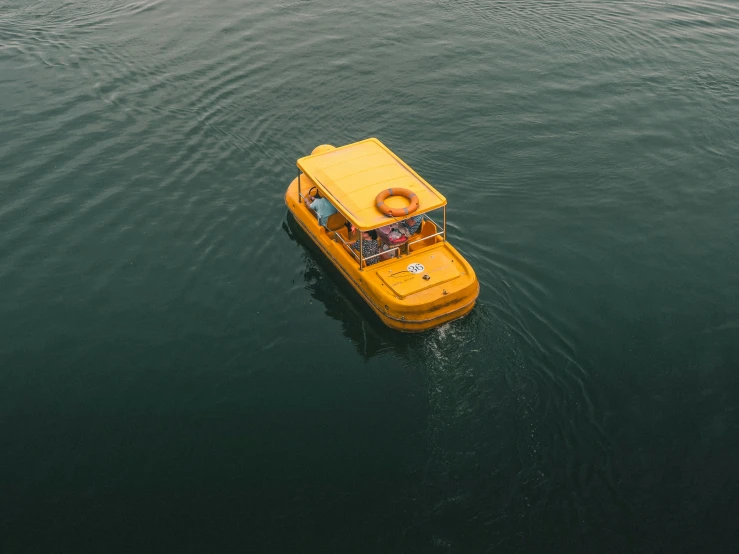 a yellow boat floating down the ocean near shore