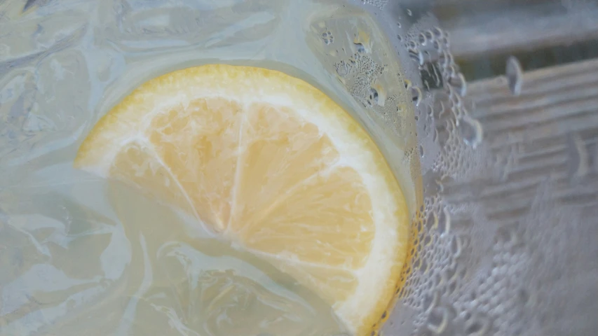 closeup of slice of lemon next to water