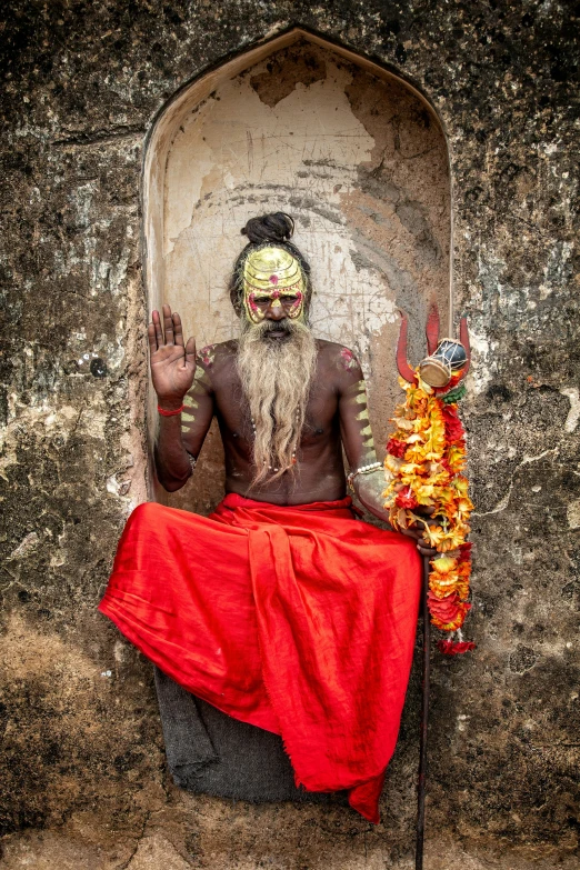 man wearing costume sitting on small throne in old setting