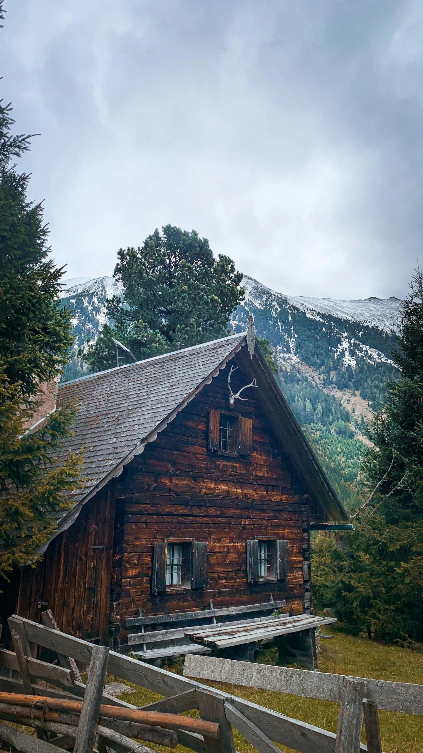 an old wooden cabin sits along the mountainside