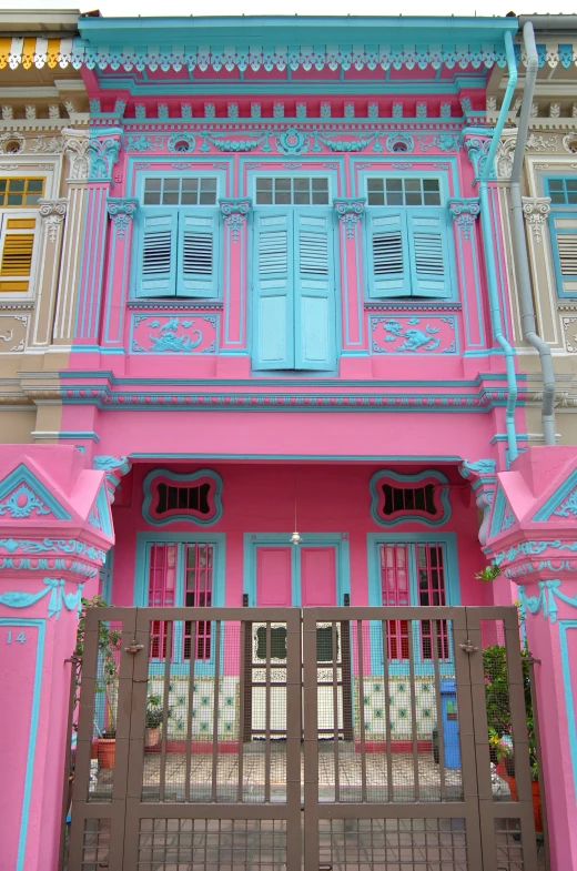 a pink and blue house with wood gates