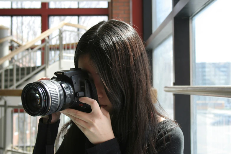 a woman taking a picture with her camera in a large room