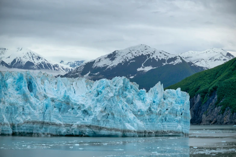 snow capped mountains surrounding a glacier and water