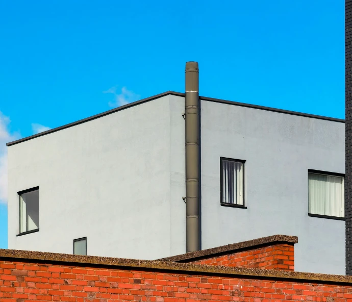 a red brick wall and a white house with windows