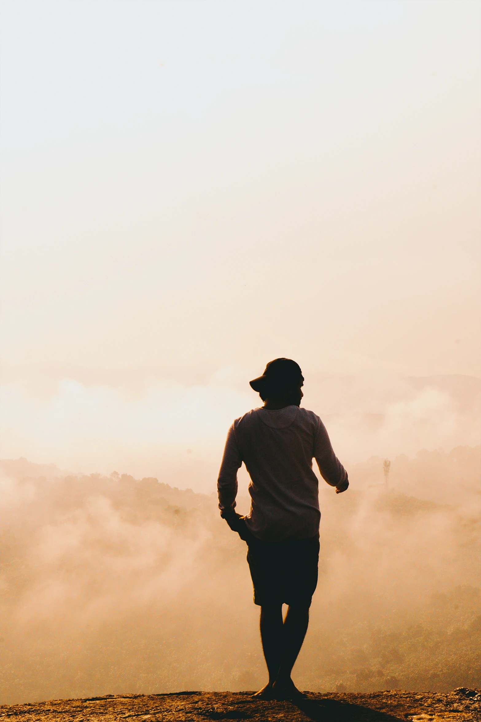 man looking out at the sky as he hikes along a trail