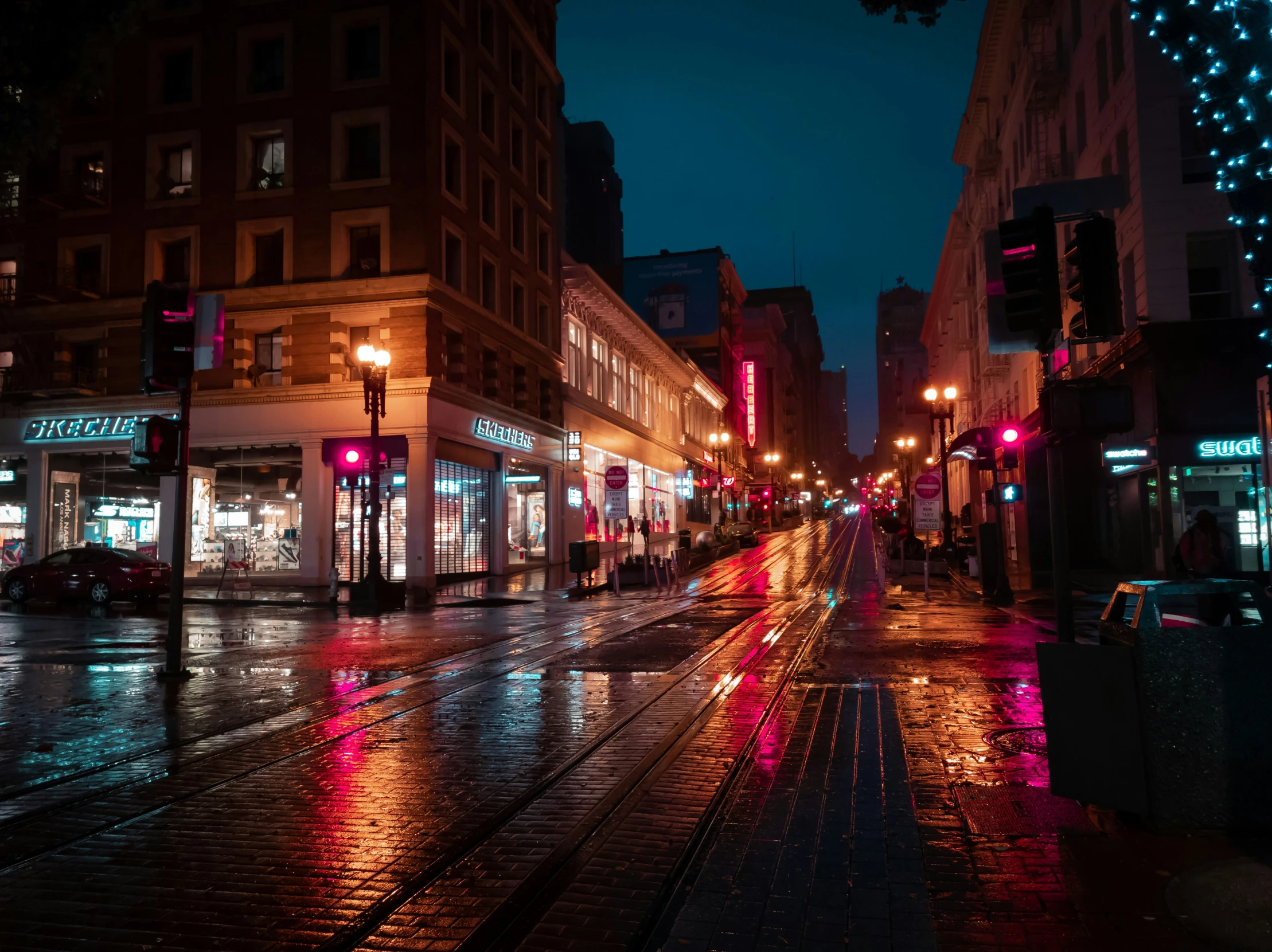 wet street with lit buildings and cars at night