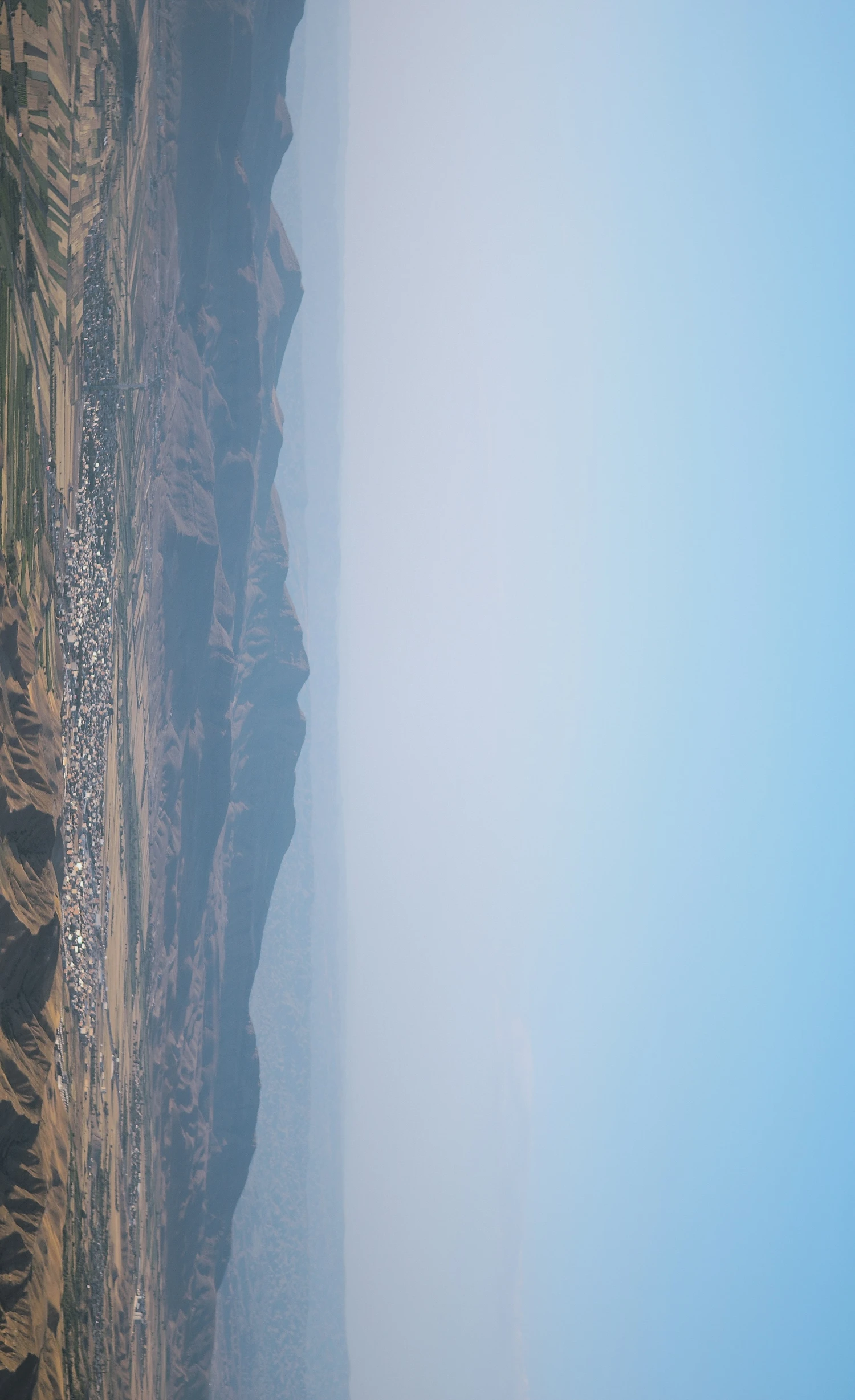 a view from an airplane looking over the top of a hill and down the side