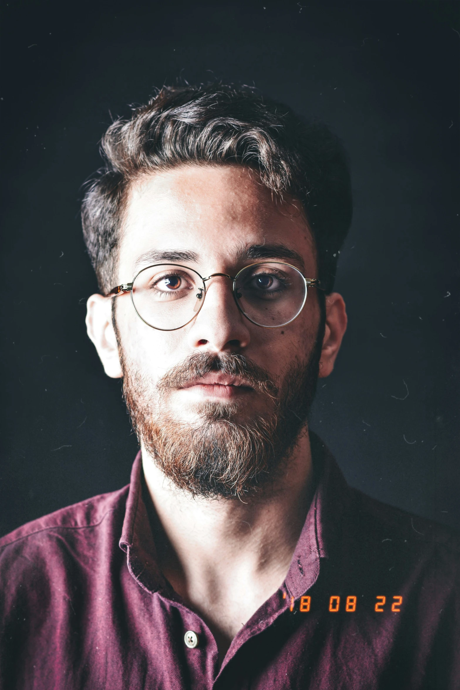 a man with glasses and a beard posing for a portrait