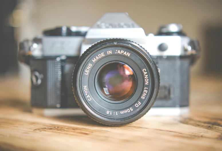 a black and white camera on a wooden table