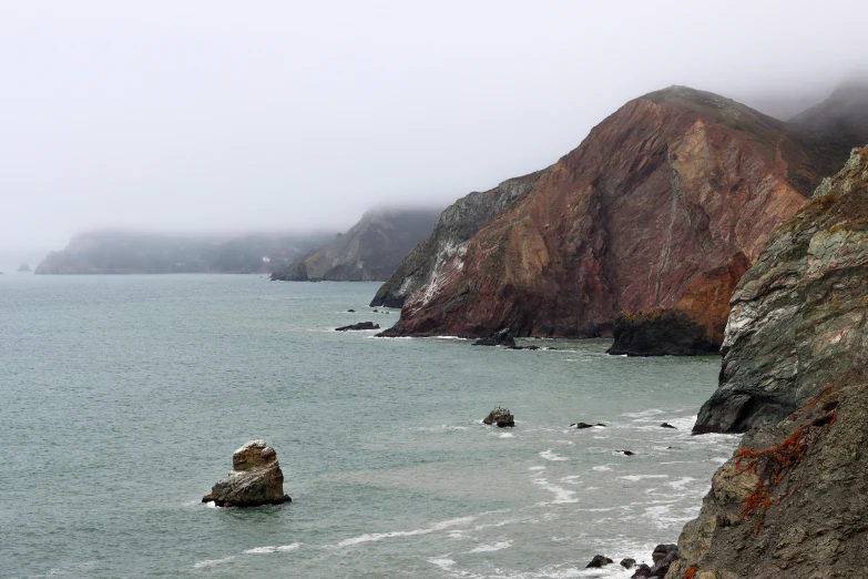 large rocks sticking out of the ocean with water below