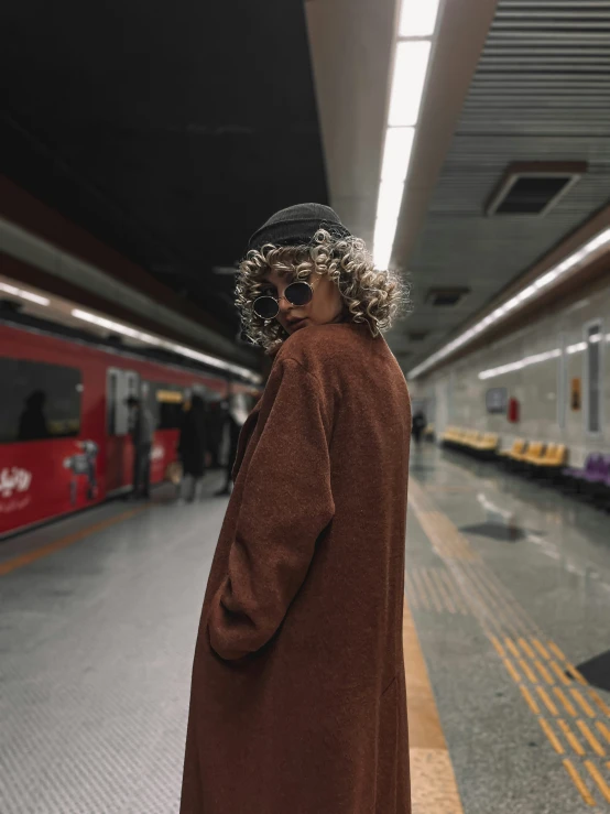 a person with sunglasses on their head walking toward a subway