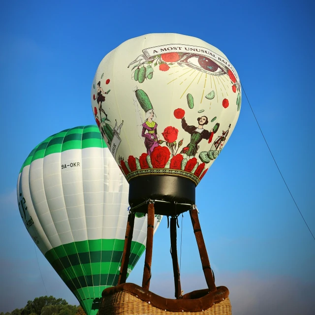 two  air balloons in the shape of people on a sunny day