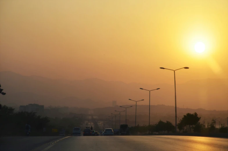 the sun is just setting over a highway with traffic