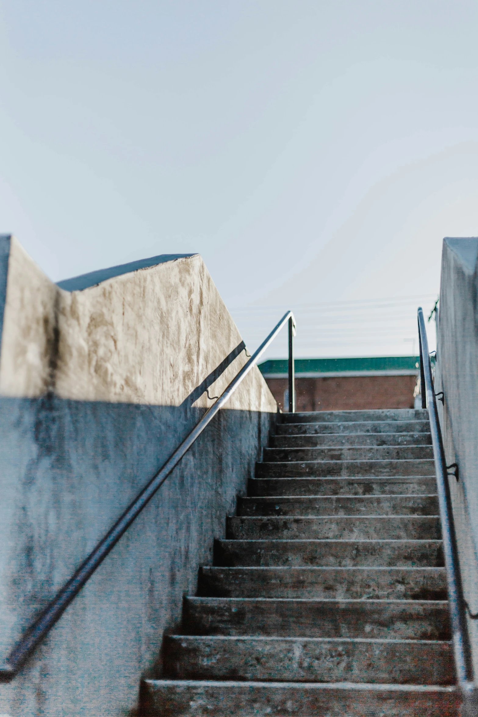 a man riding his skateboard down a rail next to some stairs