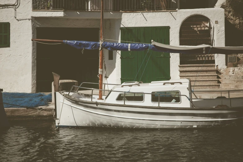 a boat sitting in the water beside a building