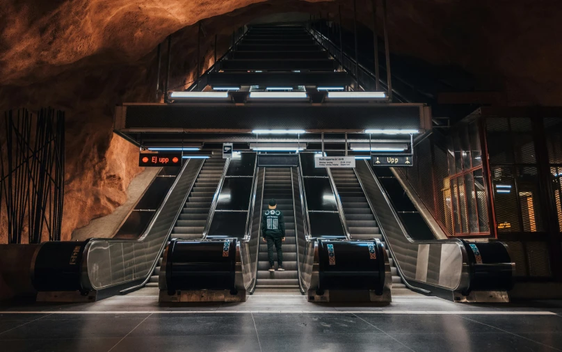 two large escalators next to a tunnel in a building