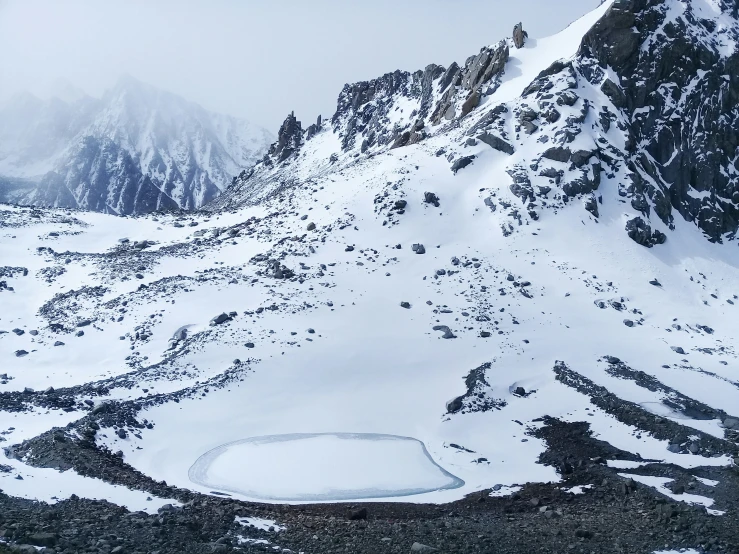 a snow covered mountain with a lake below