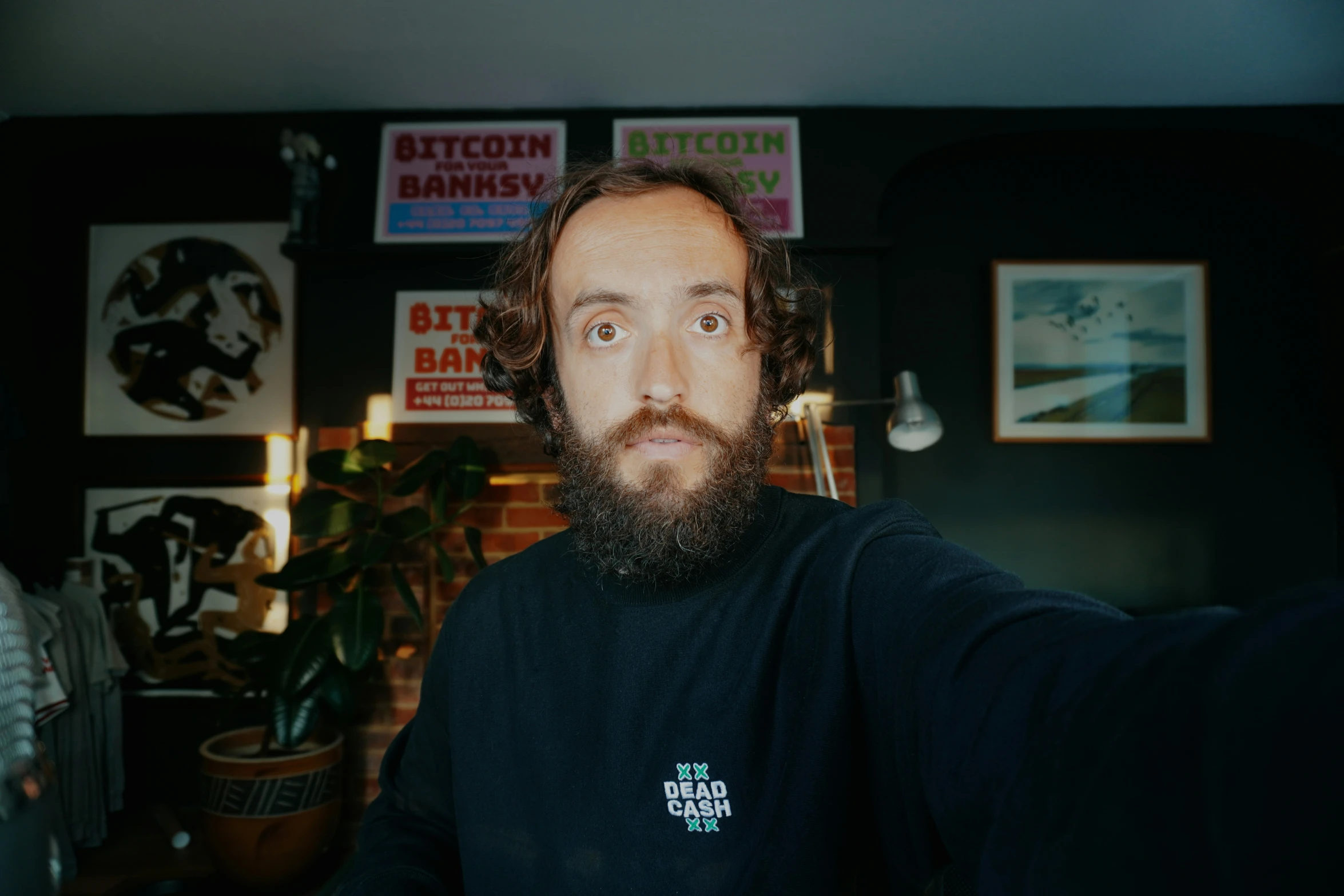 a man with a full beard and dark shirt taking a selfie
