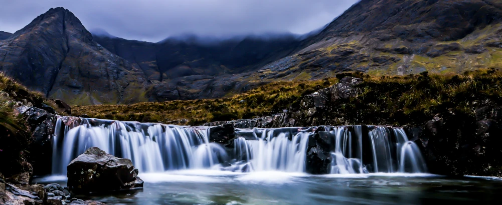 a waterfall with some rocks in the water