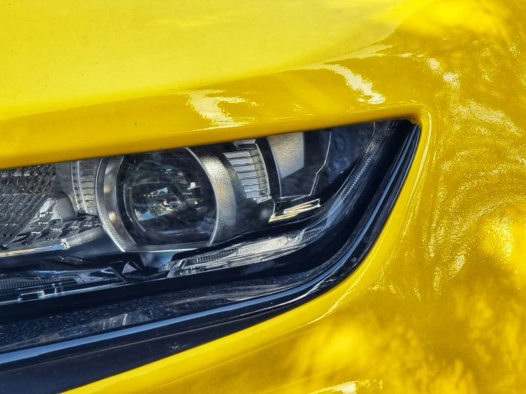 closeup of a bright yellow sports car headlight