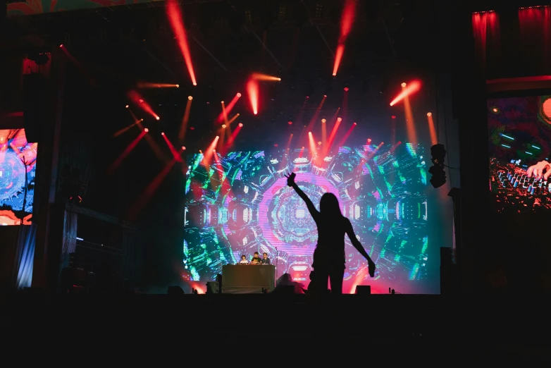 people standing on a stage while holding their arms up