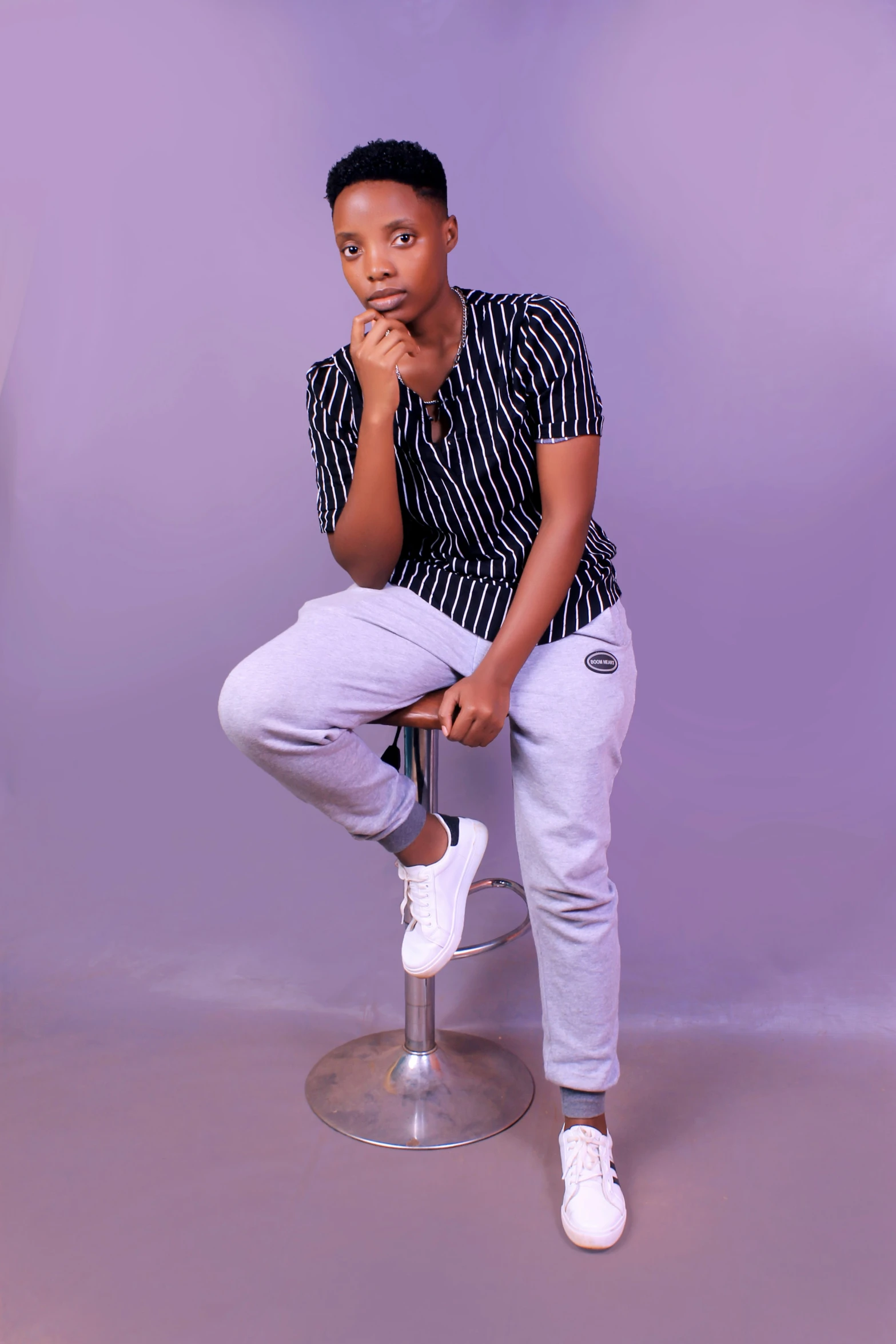 an african american boy poses on a stool