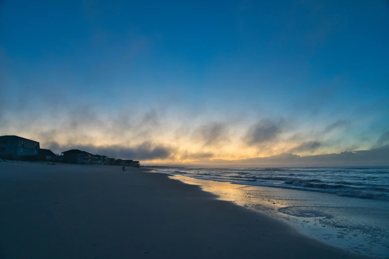 a sunrise at the beach and some houses