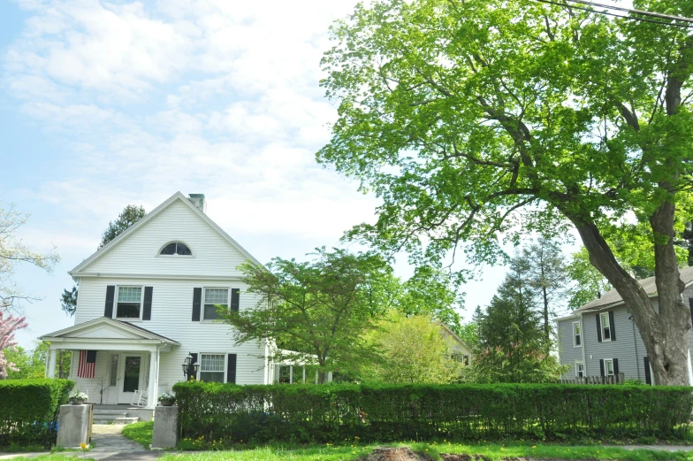 a house on a street corner with a hedge around it