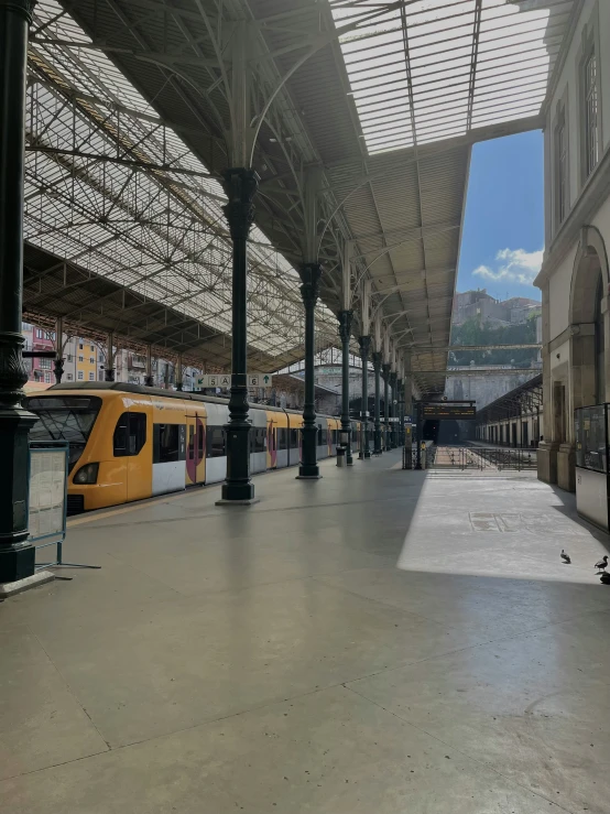 a train station with yellow and grey trains