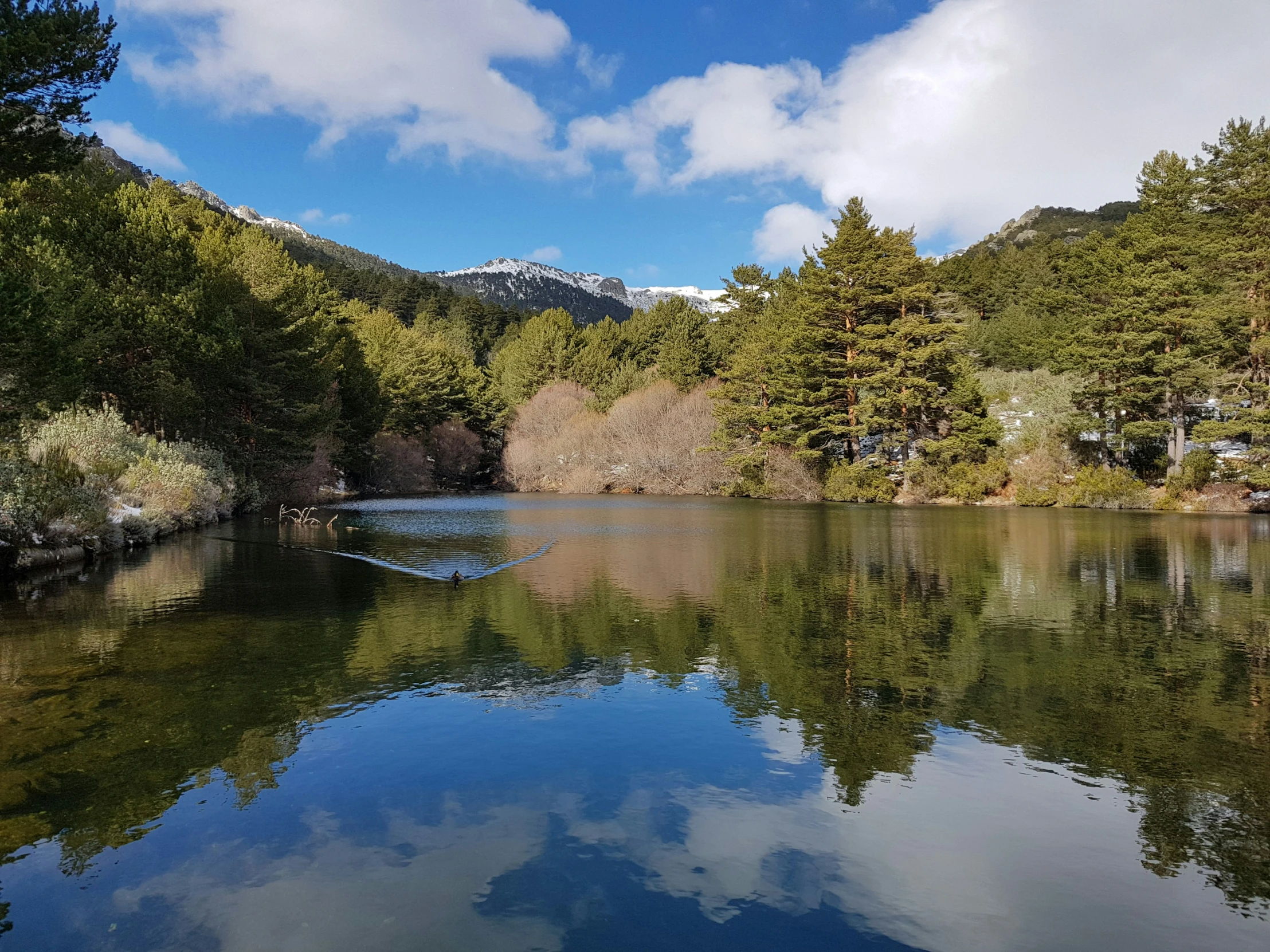 the sky is reflected in the still water of this lake