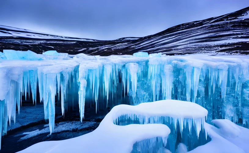 ice covered waterfall in winter with mountains in background