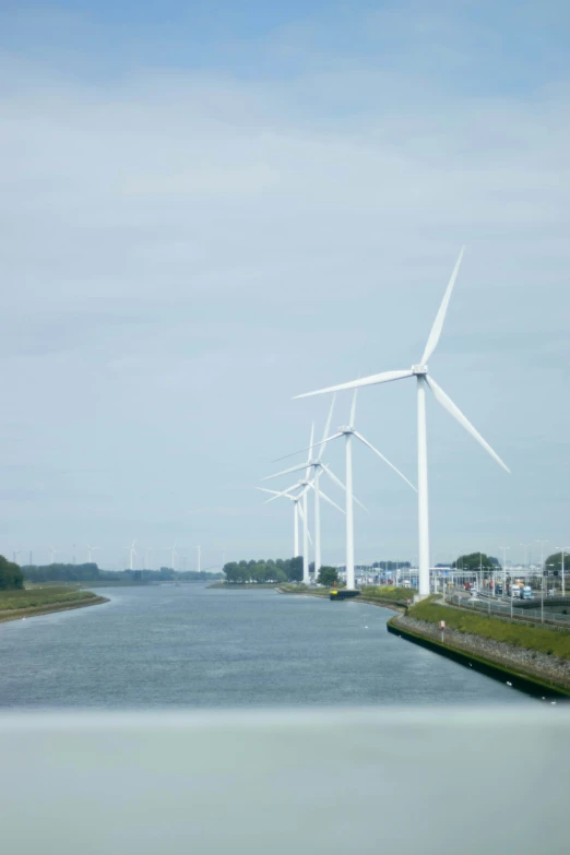 a river with wind turbines and power generating areas near it